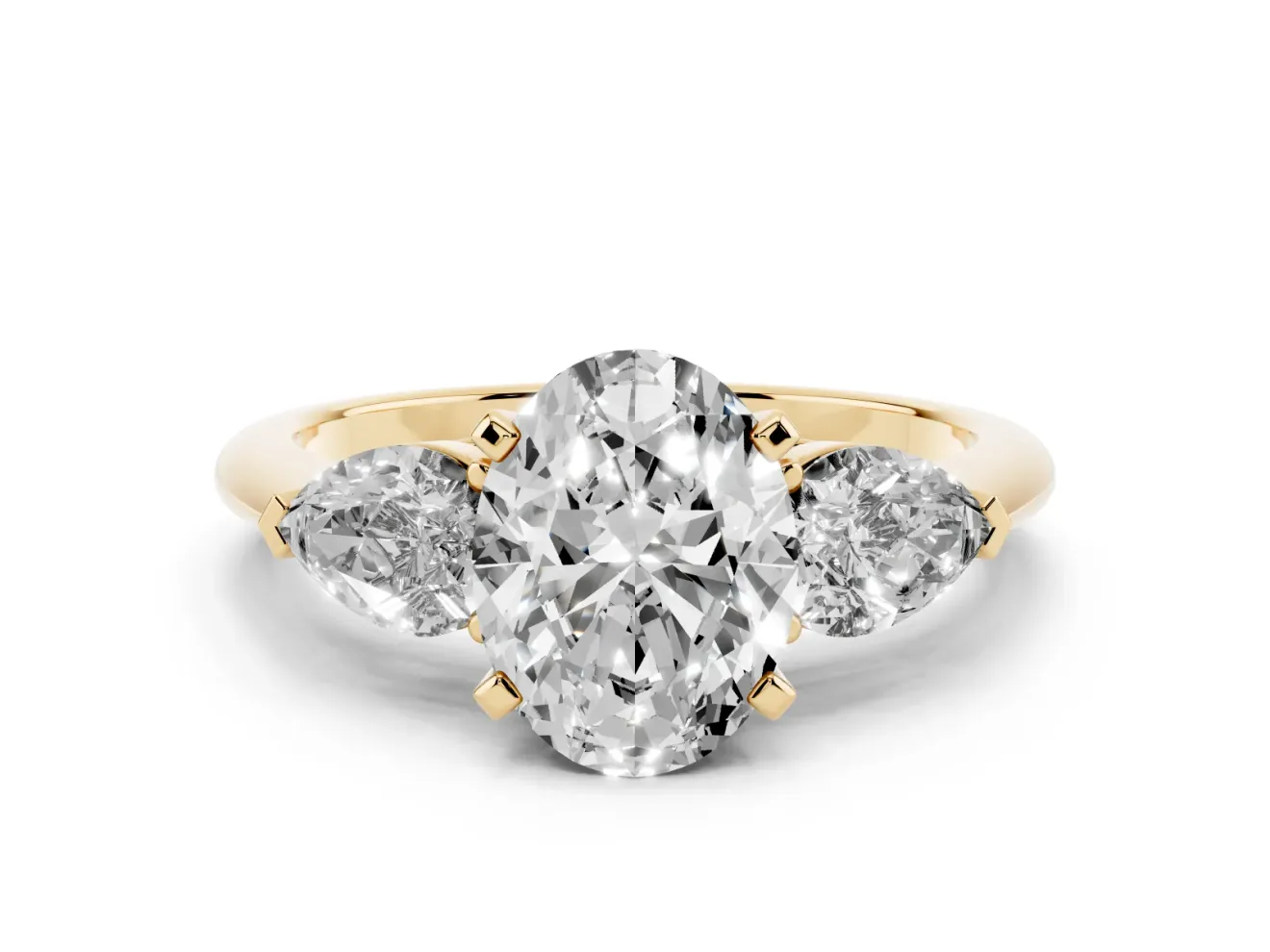 Three-Stone Oval Cut Diamond Ring Set in Yellow gold with Pear Side Stones and Prong Setting