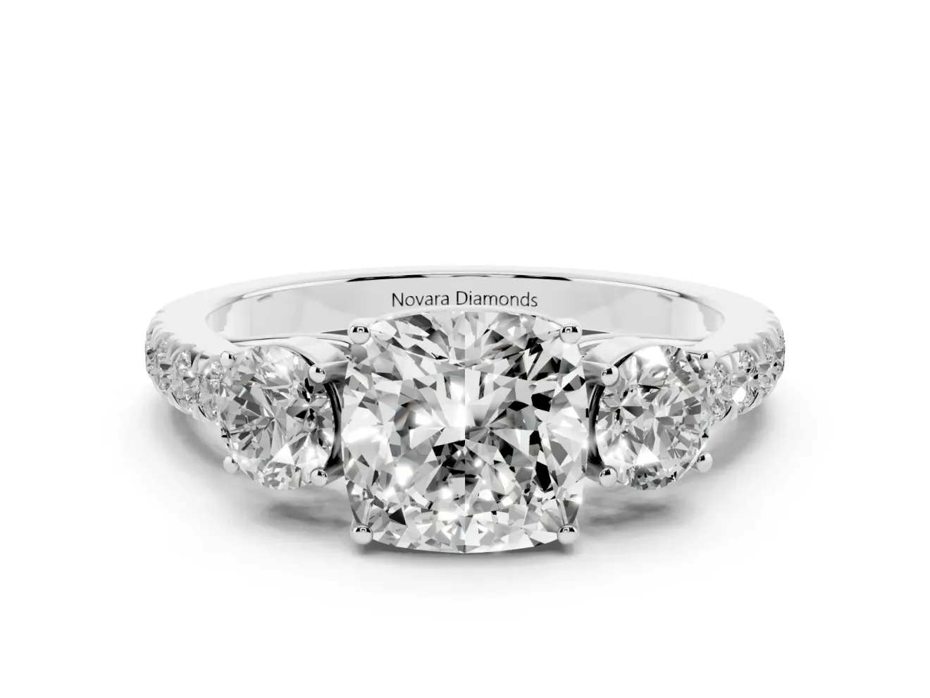Cushion Cut Diamond Three-Stone Ring Set in Platinum with Round Side Stones and Delicate Pavé Band