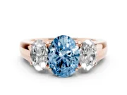 Fancy Blue Three-Stone Oval Cut Diamond Ring Set in Rose gold with Matching Prong Settings and Plain Band