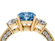 Fancy Blue Cushion Cut Diamond Three-Stone Ring Set in Yellow gold with Round Side Stones and Pavé Band