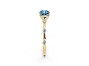 Fancy Blue Cushion Cut Diamond Solitaire Ring Set in Yellow gold with Bezel Set Side Stones and Prong Setting