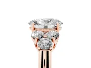 Oval Cut Diamond Cluster Ring Set in Rose gold with Round Accent Stones and Prong Setting on a Plain Band