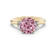 Fancy Pink Three-Stone Round Cut Diamond Ring Set in Yellow gold with Prong Setting and Plain Band
