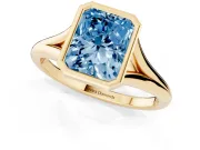Fancy Blue Bezel Set Radiant Cut Diamond Solitaire Ring Set in Yellow gold with Tapered Band