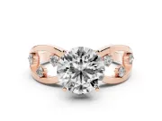 Round Cut Diamond Solitaire Ring Set in Rose gold with Side Stones on Criss-Cross Band and Prong Setting
