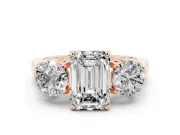 Emerald Cut Diamond Three-Stone Ring Set in Rose gold with Round Accent Stones and Plain Band