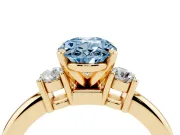 Fancy Blue Three-Stone Oval Cut Diamond Ring Set in Yellow gold with Prong Setting and Plain Band