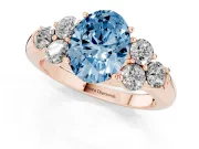 Fancy Blue Oval Cut Diamond Cluster Ring Set in Rose gold with Round Accent Stones and Prong Setting on a Plain Band