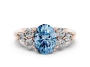 Fancy Blue Oval Cut Diamond Cluster Ring Set in Rose gold with Round Accent Stones and Prong Setting on a Plain Band