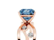 Fancy Blue Princess Cut Diamond Solitaire Ring Set in Rose gold with Side Stones on Criss-Cross Band and Prong Setting