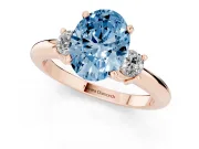 Fancy Blue Three-Stone Oval Cut Diamond Ring Set in Rose gold with Prong Setting and Plain Band