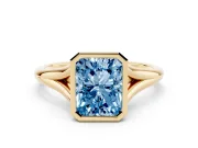 Fancy Blue Bezel Set Radiant Cut Diamond Solitaire Ring Set in Yellow gold with Tapered Band