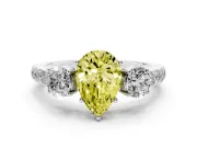 Fancy Yellow Pear Cut Diamond Three-Stone Ring Set in Platinum with Round Side Stones and Delicate Pavé Band
