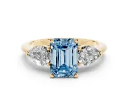 Fancy Blue Three-Stone Emerald Cut Diamond Ring Set in Yellow gold with Pear Side Stones and Prong Setting