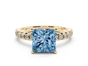 Fancy Blue Princess Cut Diamond Solitaire Pavé Engagement Ring Set in Yellow gold with Round Band and Prong Setting