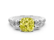 Fancy Yellow Cushion Cut Diamond Three-Stone Ring Set in Platinum with Round Side Stones and Delicate Pavé Band