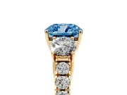 Fancy Blue Cushion Cut Diamond Three-Stone Ring Set in Yellow gold with Round Side Stones and Delicate Pavé Band