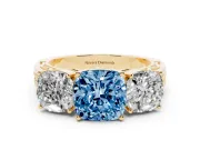 Fancy Blue Cushion Cut Diamond Three-Stone Ring Set in Yellow gold with Textured Band