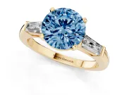 Fancy Blue Round Cut Diamond Solitaire Ring Set in Yellow gold with Tapered Baguette Side Stones and Prong Setting