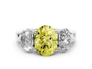 Fancy Yellow Oval Cut Diamond Three-Stone Ring Set in Platinum with Bold Center and Classic Band