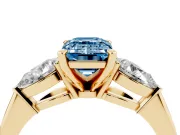Fancy Blue Three-Stone Emerald Cut Diamond Ring Set in Yellow gold with Pear Side Stones and Prong Setting