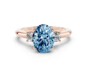 Fancy Blue Three-Stone Oval Cut Diamond Ring Set in Rose gold with Prong Setting and Plain Band