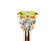Fancy Yellow Oval Cut Diamond Cluster Ring Set in Yellow gold with Round Accent Stones and Prong Setting on a Plain Band