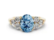 Fancy Blue Oval Cut Diamond Cluster Ring Set in Yellow gold with Round Accent Stones and Prong Setting on a Plain Band