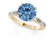 Fancy Blue Round Cut Diamond Solitaire Set in Yellow gold with Side Baguettes and Channel Set Band