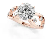 Round Cut Diamond Solitaire Ring Set in Rose gold with Side Stones on Criss-Cross Band and Prong Setting