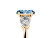 Fancy Blue Three-Stone Oval Cut Diamond Ring Set in Yellow gold with Pear Side Stones and Prong Setting