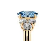 Fancy Blue Oval Cut Diamond Cluster Ring Set in Yellow gold with Round Accent Stones and Prong Setting on a Plain Band