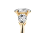 Three-Stone Oval Cut Diamond Ring Set in Yellow gold with Pear Side Stones and Prong Setting