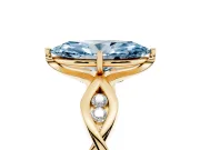 Fancy Blue Marquise Cut Diamond Twist Band Solitaire Ring Set in Yellow gold with Leaf Prong Setting and Accent Stones
