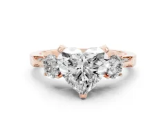 Heart Cut Diamond Three-Stone Ring Set in Rose gold with Pavé Band and Smaller Side Stones