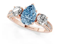 Fancy Blue Pear Cut Diamond Three-Stone Ring Set in Rose gold with Round Side Stones and Pavé Band