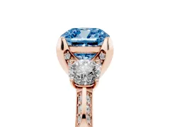 Fancy Blue Cushion Cut Diamond Three-Stone Ring Set in Rose gold with Pavé Band and Smaller Side Stones