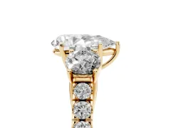 Pear Cut Diamond Three-Stone Ring Set in Yellow gold with Round Side Stones and Delicate Pavé Band