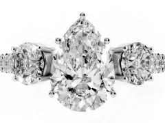 Pear Cut Diamond Three-Stone Ring Set in Platinum with Round Side Stones and Delicate Pavé Band
