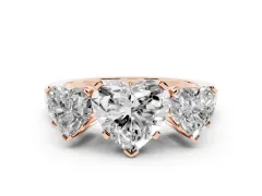 Heart Cut Diamond Three-Stone Ring Set in Rose gold with Channel-Set Band and Prong Settings