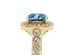 Fancy Blue Cushion Cut Diamond Milgrain Halo Solitaire Ring Set in Yellow gold with Bezel Set Side Stones and Pavé Band