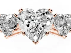 Heart Cut Diamond Three-Stone Ring Set in Rose gold with Channel-Set Band and Prong Settings