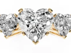 Heart Cut Diamond Three-Stone Ring Set in Yellow gold with Channel-Set Band and Prong Settings