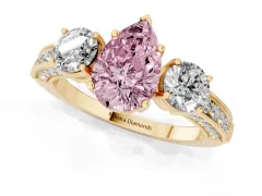Fancy Pink Pear Cut Diamond Three-Stone Ring Set in Yellow gold with Round Side Stones and Pavé Band