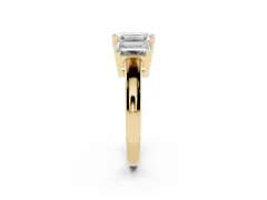 Emerald Cut Diamond Three-Stone Ring Set in Yellow gold with Channel-Set Band and Prong Settings