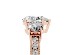 Pear Cut Diamond Three-Stone Ring Set in Rose gold with Round Side Stones and Pavé Band