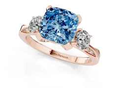 Fancy Blue Cushion Cut Diamond Three-Stone Ring Set in Rose gold with Pavé Band and Smaller Side Stones
