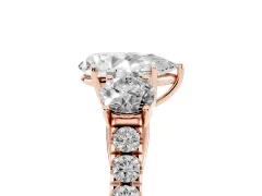Pear Cut Diamond Three-Stone Ring Set in Rose gold with Round Side Stones and Delicate Pavé Band
