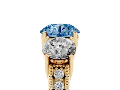 Fancy Blue Round Cut Diamond Three-Stone Engagement Ring Set in Yellow gold with Milgrain Pavé Band