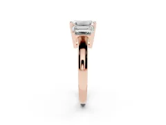 Emerald Cut Diamond Three-Stone Ring Set in Rose gold with Channel-Set Band and Prong Settings